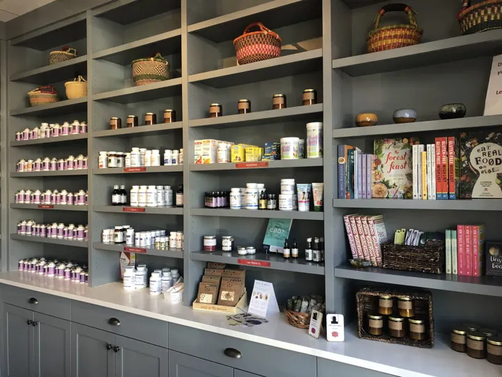 Apothecary shelves stocked with supplements, herbs and books